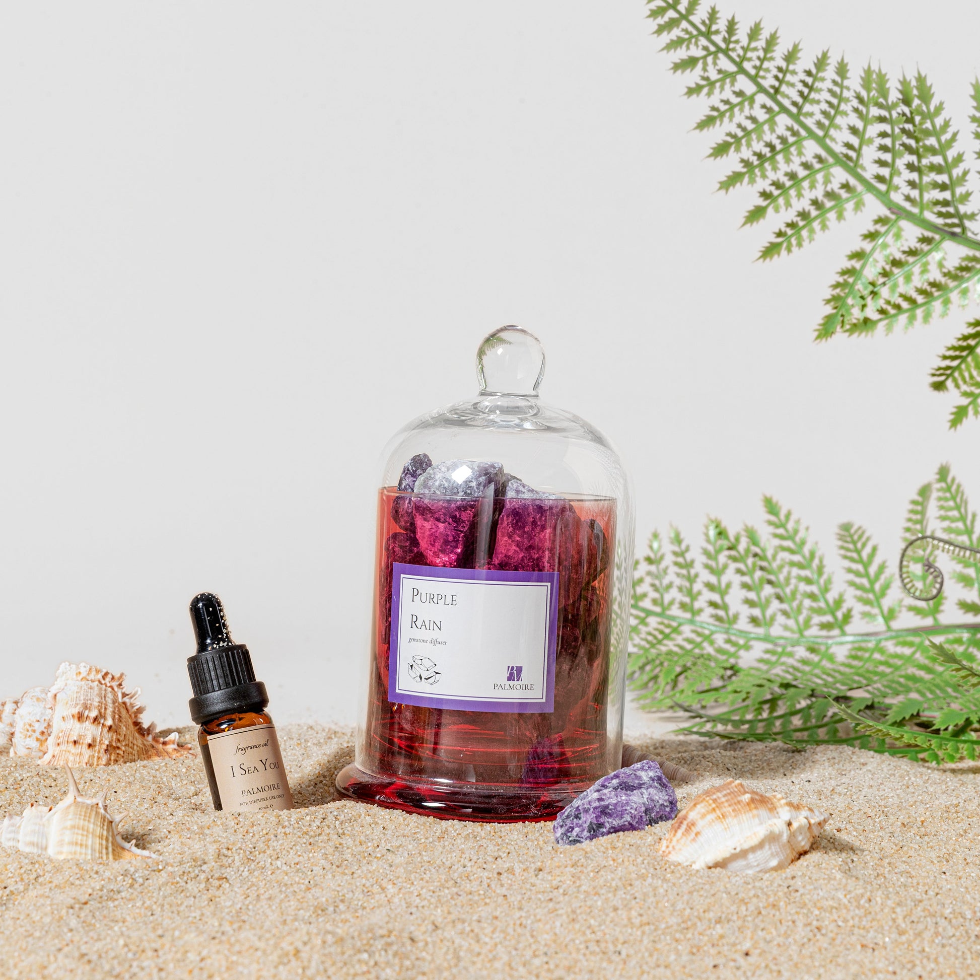 Purple Rain Gemstone Diffuser with I Sea You fragrance oil on a beach with sea shells